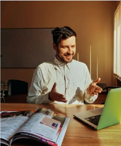 a man at a table in front of a laptop