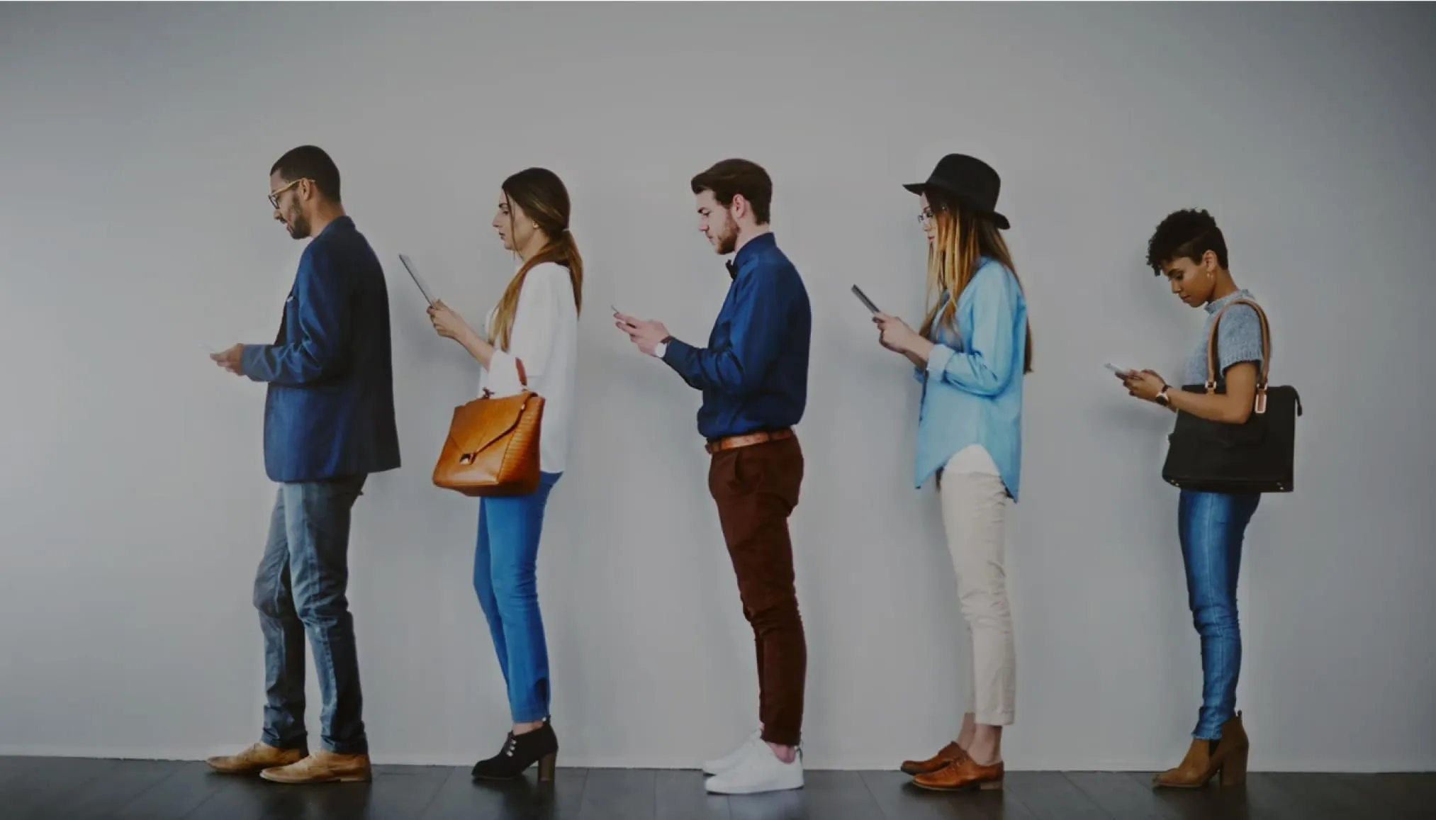 a group of people in line looking at their mobile devices